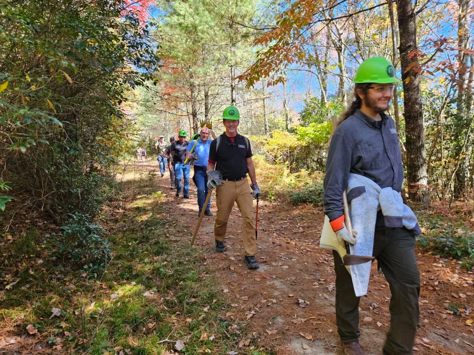 Group carrying tools along a forest trail